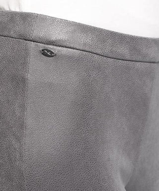 Close-up of grey faux suede leggings with textured finish and small metal accent detail