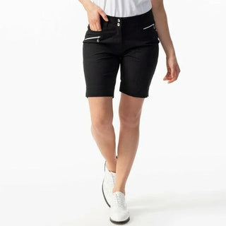 Woman wearing black knee-length shorts with zippered pockets and white sneakers