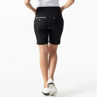 Black women's golf shorts with back pockets, modeled from behind, white background