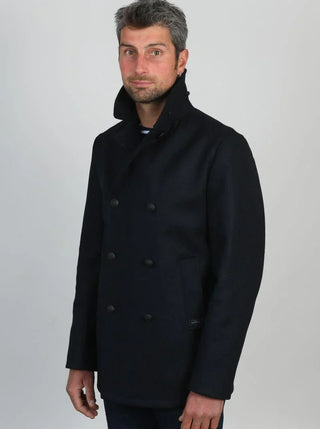 Man wearing a navy wool pea coat with high collar and double-breasted buttons