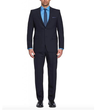 Man wearing a dark navy suit with blue dress shirt and patterned tie, full body view.