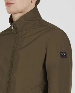 Men's olive nylon zip-up jacket with high collar and logo patch on sleeve