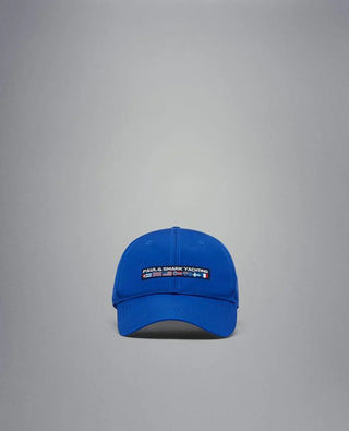 Blue nylon yachting cap with embroidered logo and nautical flags on the front, isolated background
