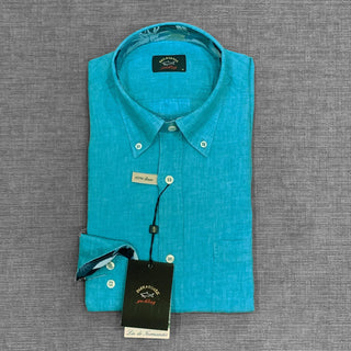 Folded turquoise linen long sleeve shirt with button-down collar and tag on gray background